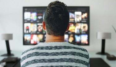 A stock photo of a man watching TV